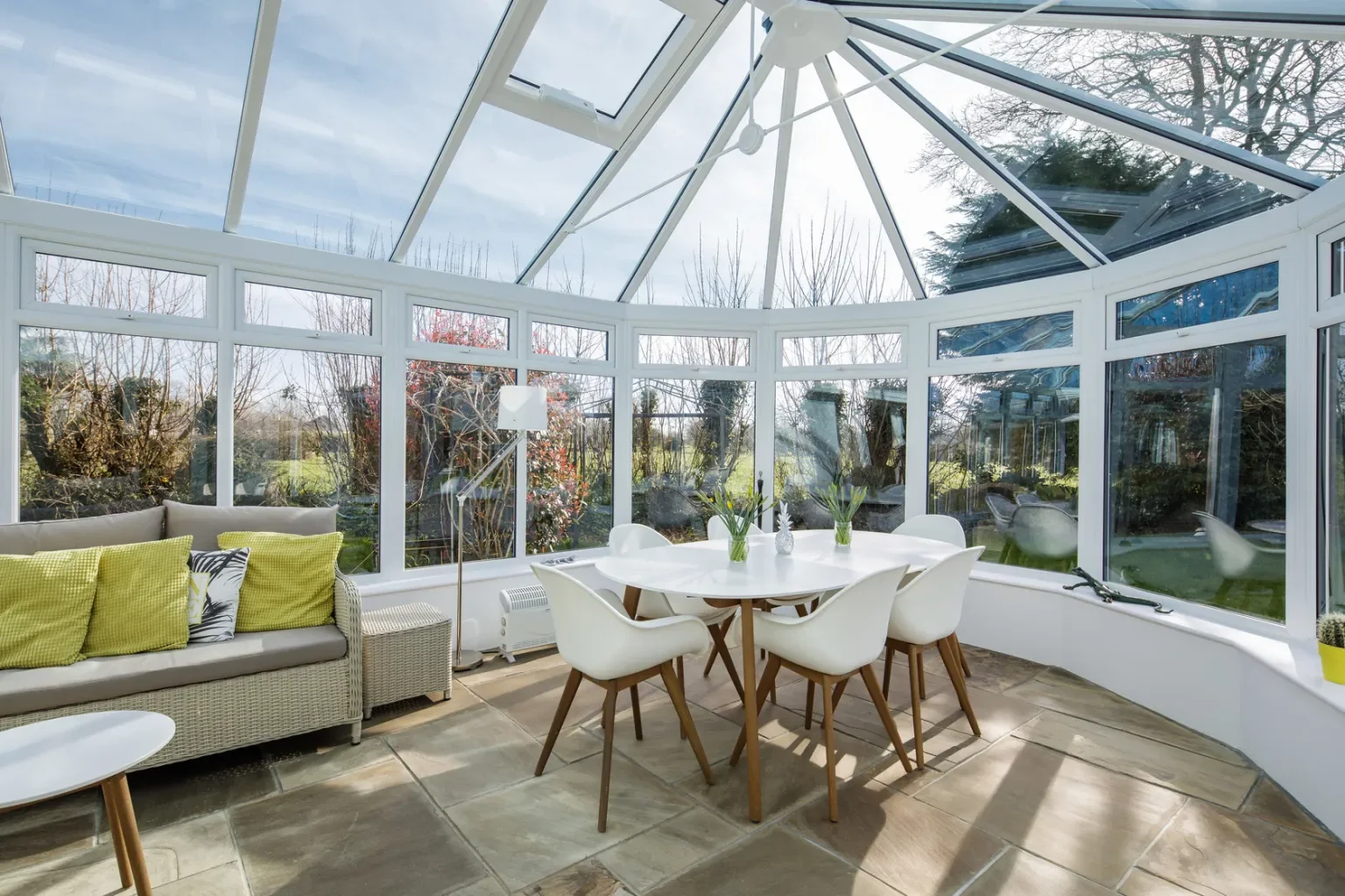 White glazed conservatory with a glass roof and views of the garden
