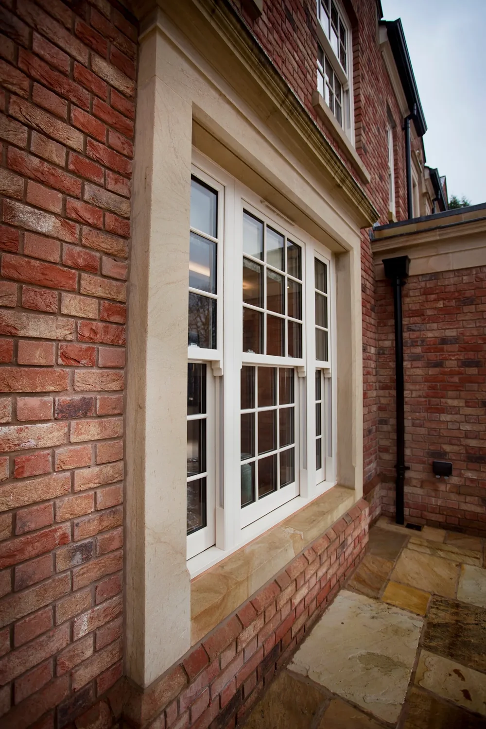Traditional white sliding sash windows on a brick home
