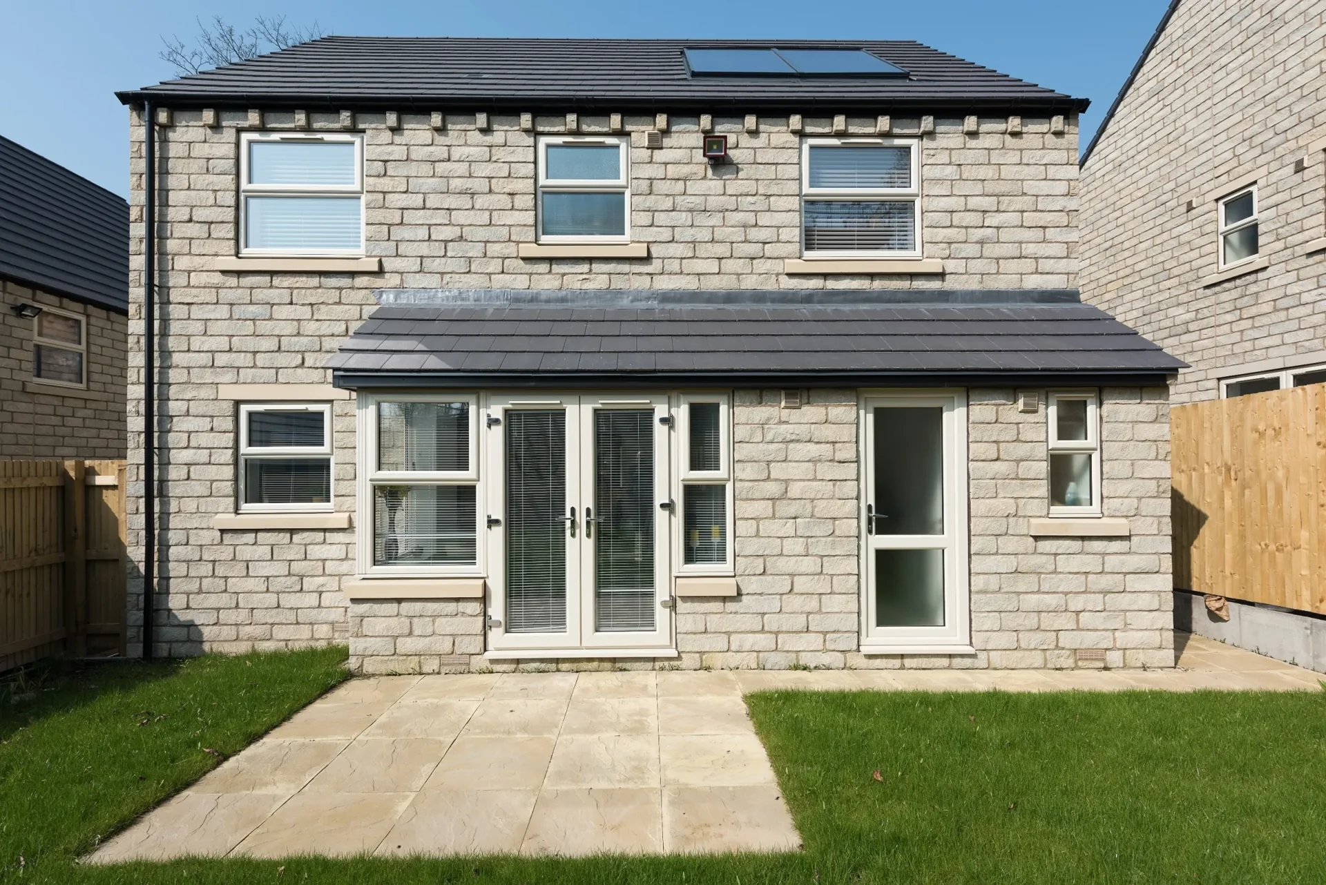 Stone home with white framed windows and garden doors